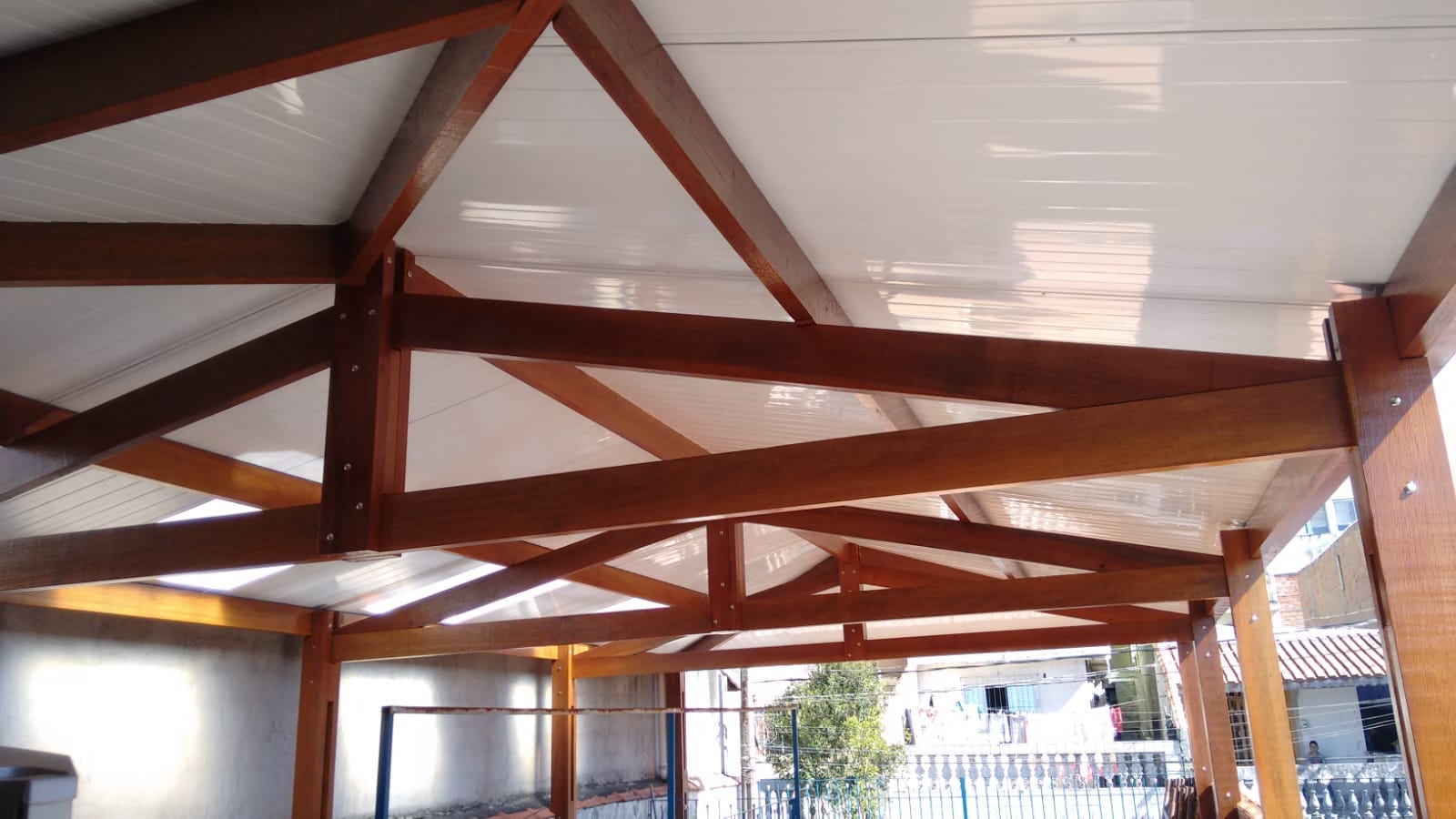 Cobertura residencial com telha de forro branco e estrutura de madeira